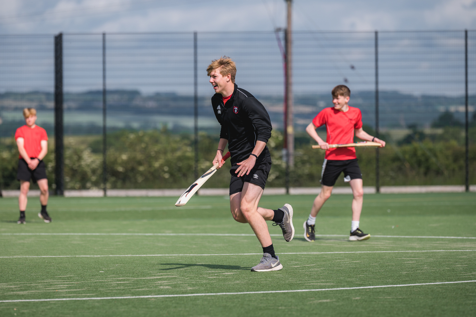 Students playing cricket on the Astroturf.