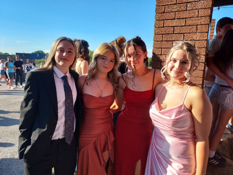 Four pupils posing for a photo outside the hotel's main entrance.