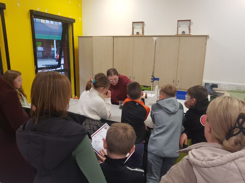 A group of visitors trying a school activity on the Year 5 & 6 Open Evening.