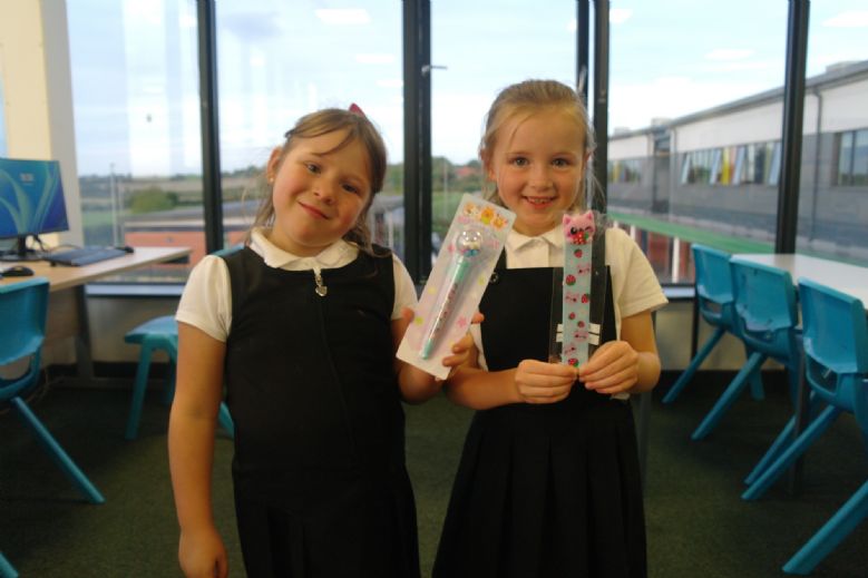 Two pupils with some stationery to buy from the book fair.
