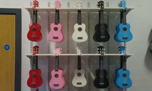 Two rows of colourful ukuleles in the music room at Tibshelf Community School.